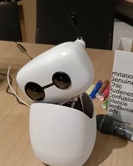 Reachy Mini tilting its head on a desk, shared by Jun