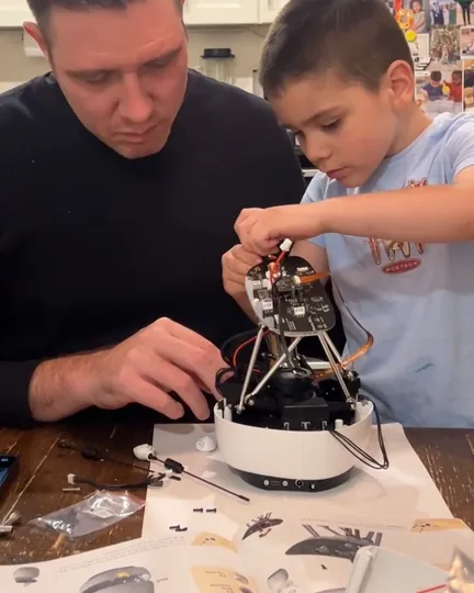 A father and his 4-year-old son assembling Reachy Mini, shared by Christopher Morley, MD