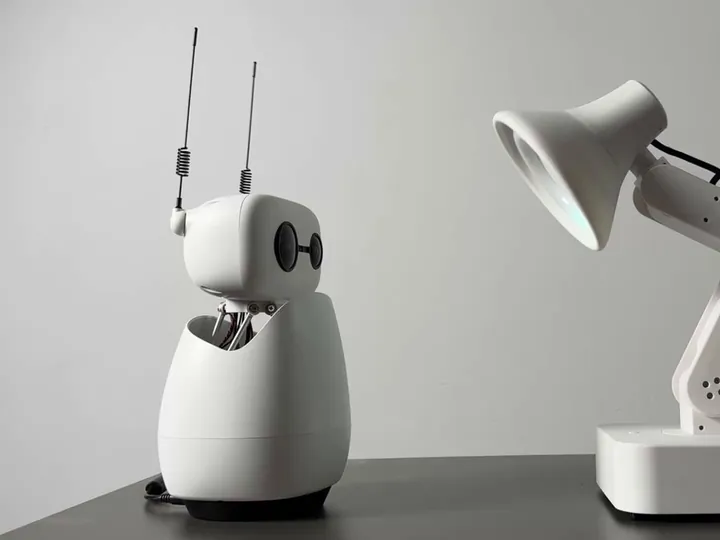 Reachy Mini talking with a robot desk lamp, shared by Dee