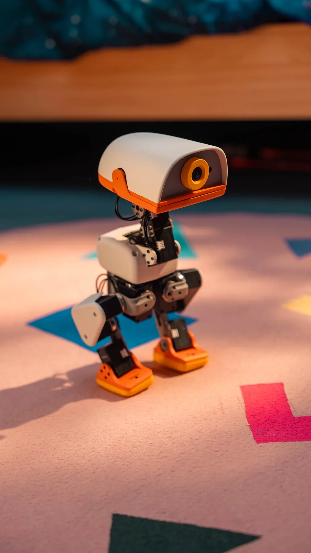 A Microduck standing on a pink rug in a child's playroom