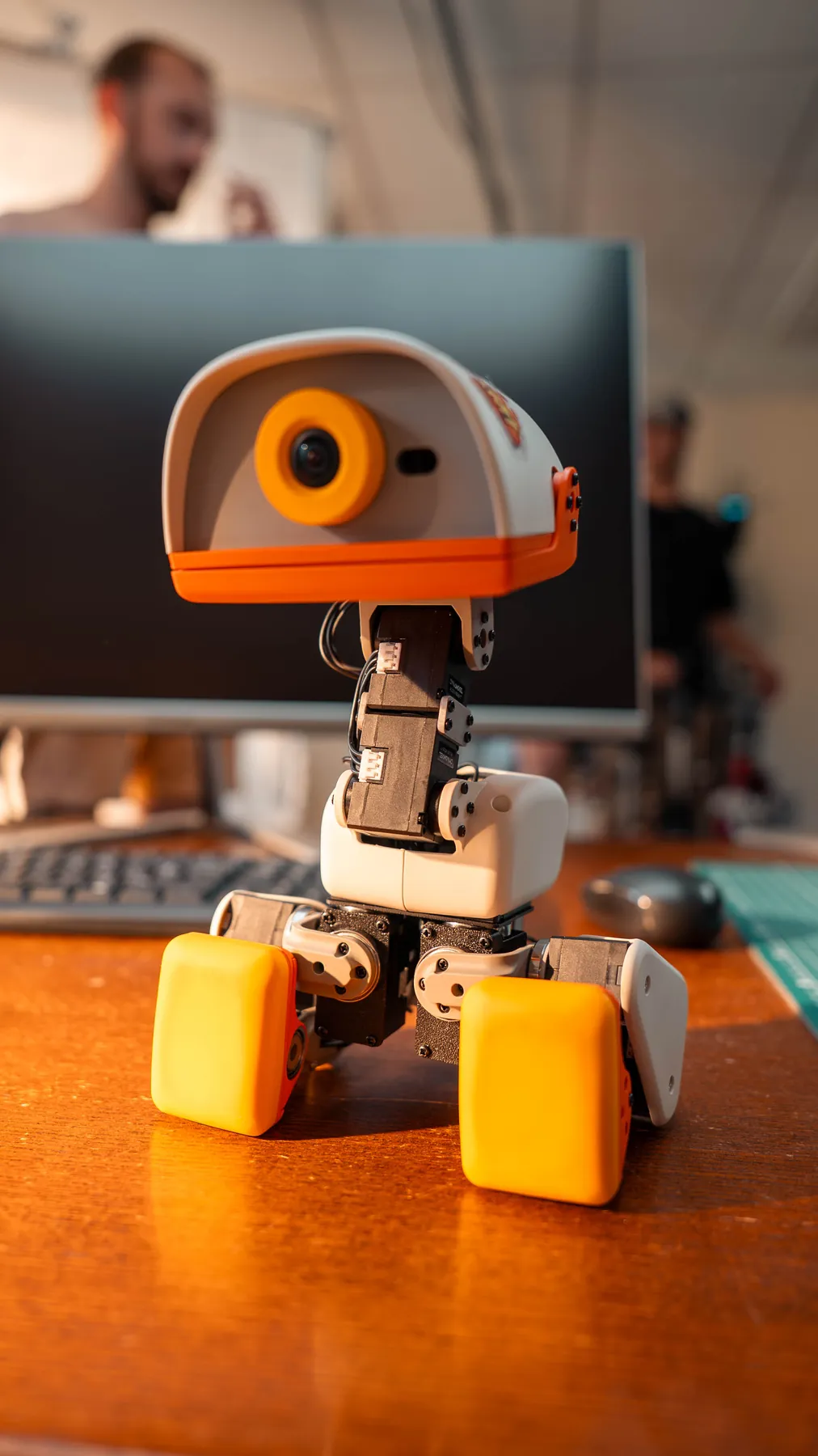 A Microduck standing in front of a laptop screen in teal light